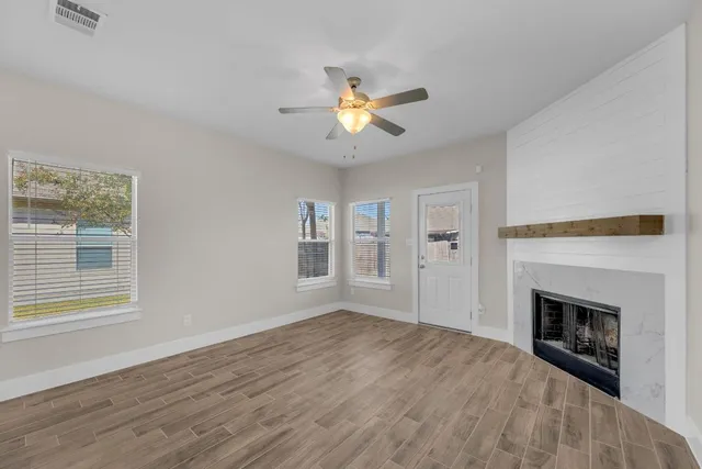 a view of empty room with fireplace and fan