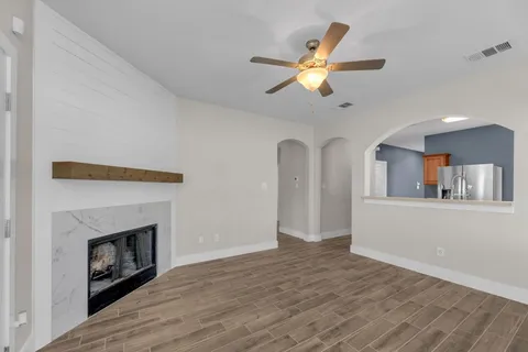 a view of empty room with fireplace and fan