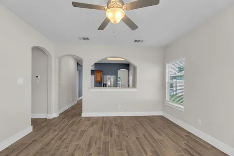 a kitchen with a sink dishwasher a stove and white cabinets with wooden floor