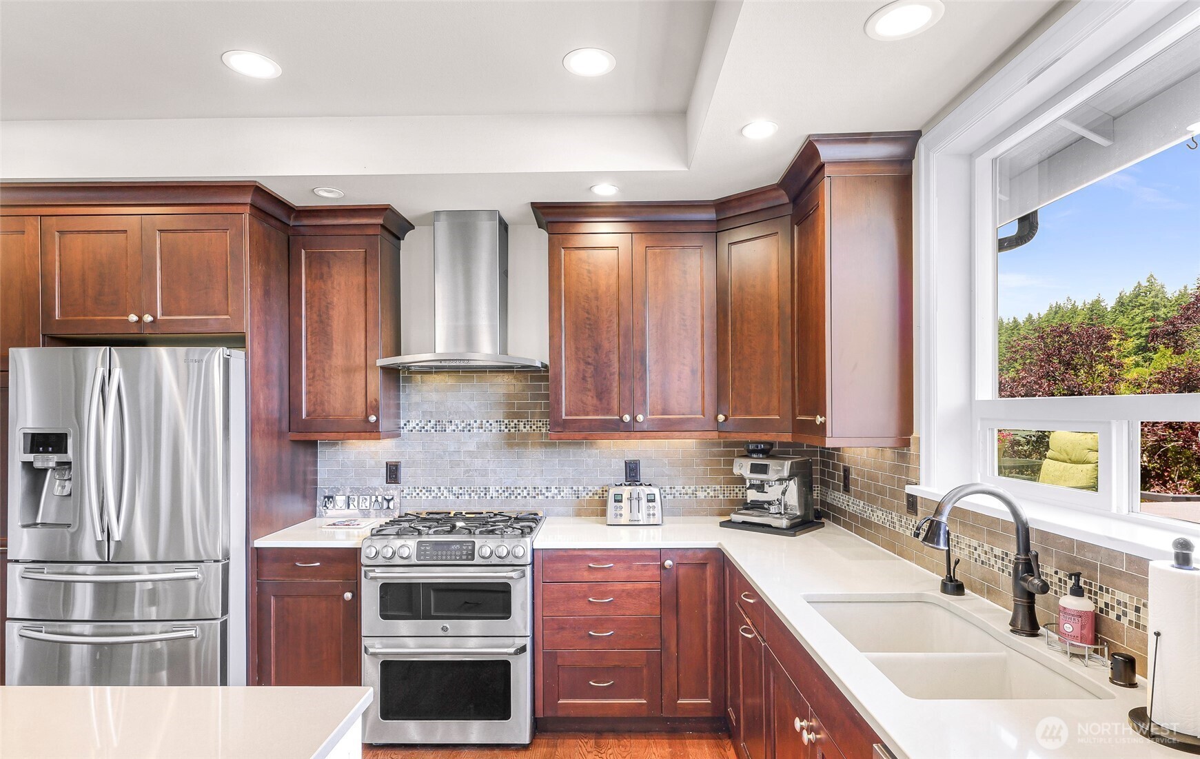 1301 Broad Street Bellingham, WA 98229 - Photo 16 of 40 a kitchen with stainless steel appliances granite countertop a stove a sink and a refrigerator