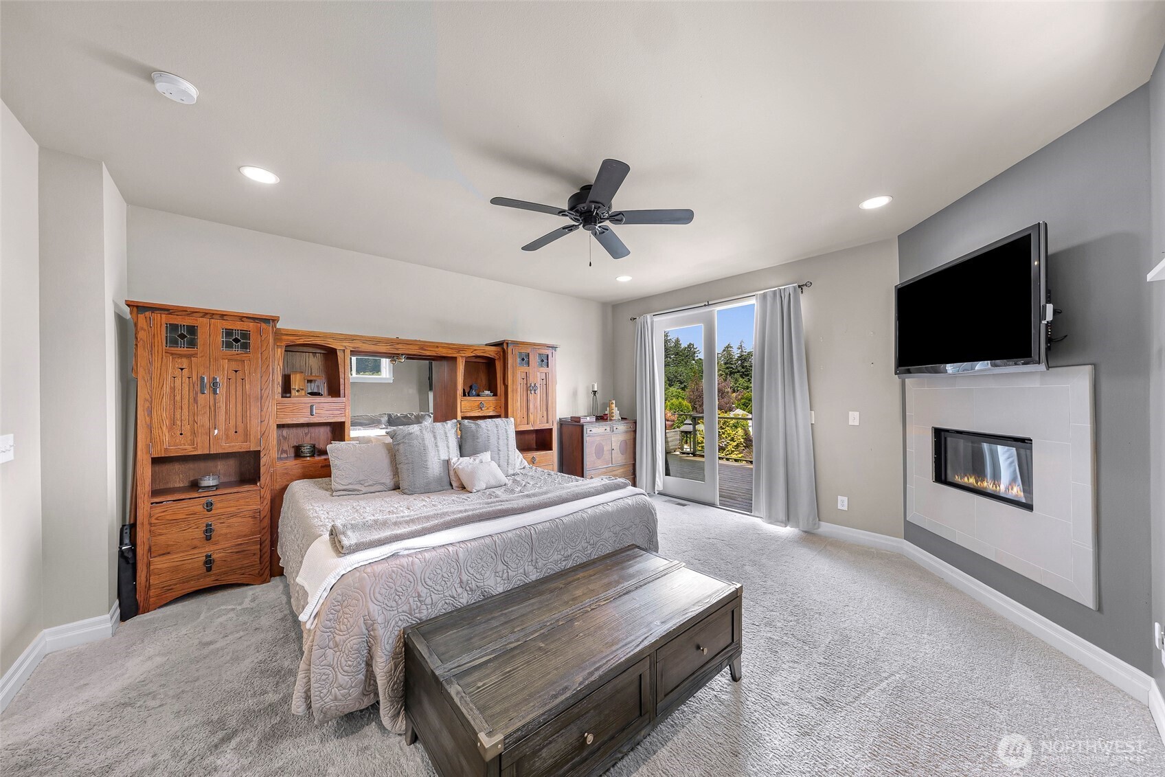 1301 Broad Street Bellingham, WA 98229 - Photo 21 of 40 a bedroom with a bed a flat screen tv and a fireplace