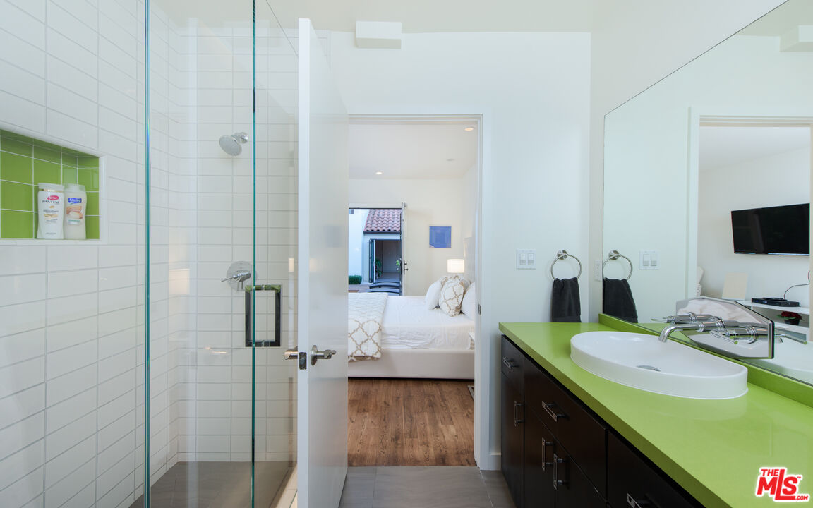 441 North Kings Road Los Angeles, CA 90048 - Photo 17 of 36 a en suite bathroom with a granite countertop sink and a mirror