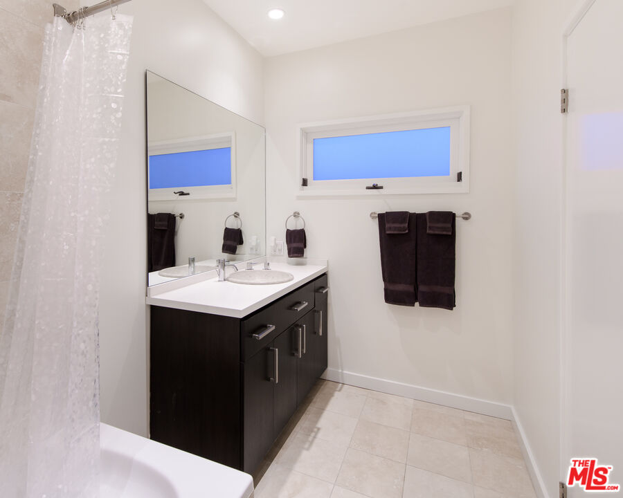 441 North Kings Road Los Angeles, CA 90048 - Photo 22 of 36 a utility room with stainless steel appliances a stove a microwave and a refrigerator