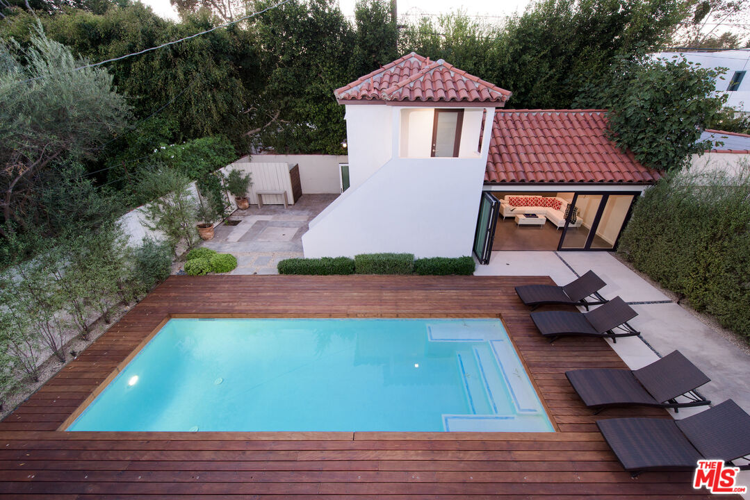 441 North Kings Road Los Angeles, CA 90048 - Photo 29 of 36 a view of a patio with table and chairs with wooden floor and fence