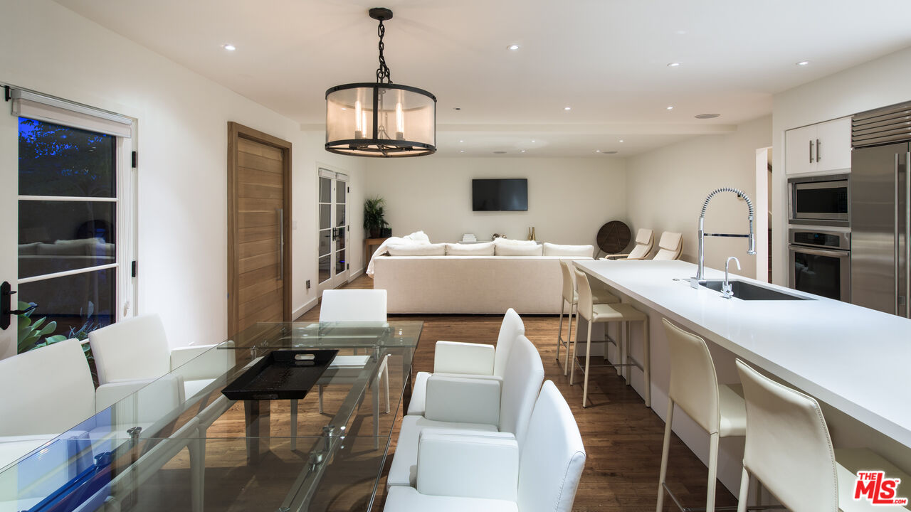 441 North Kings Road Los Angeles, CA 90048 - Photo 3 of 36 a very nice looking room with kitchen island furniture a rug and a chandelier