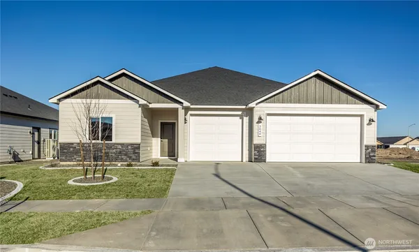 a front view of a house with yard and green space