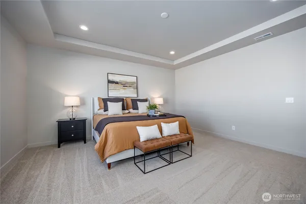 a bedroom with a bed and a lamp on desk