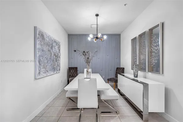 a dining room with chandelier and wooden floor