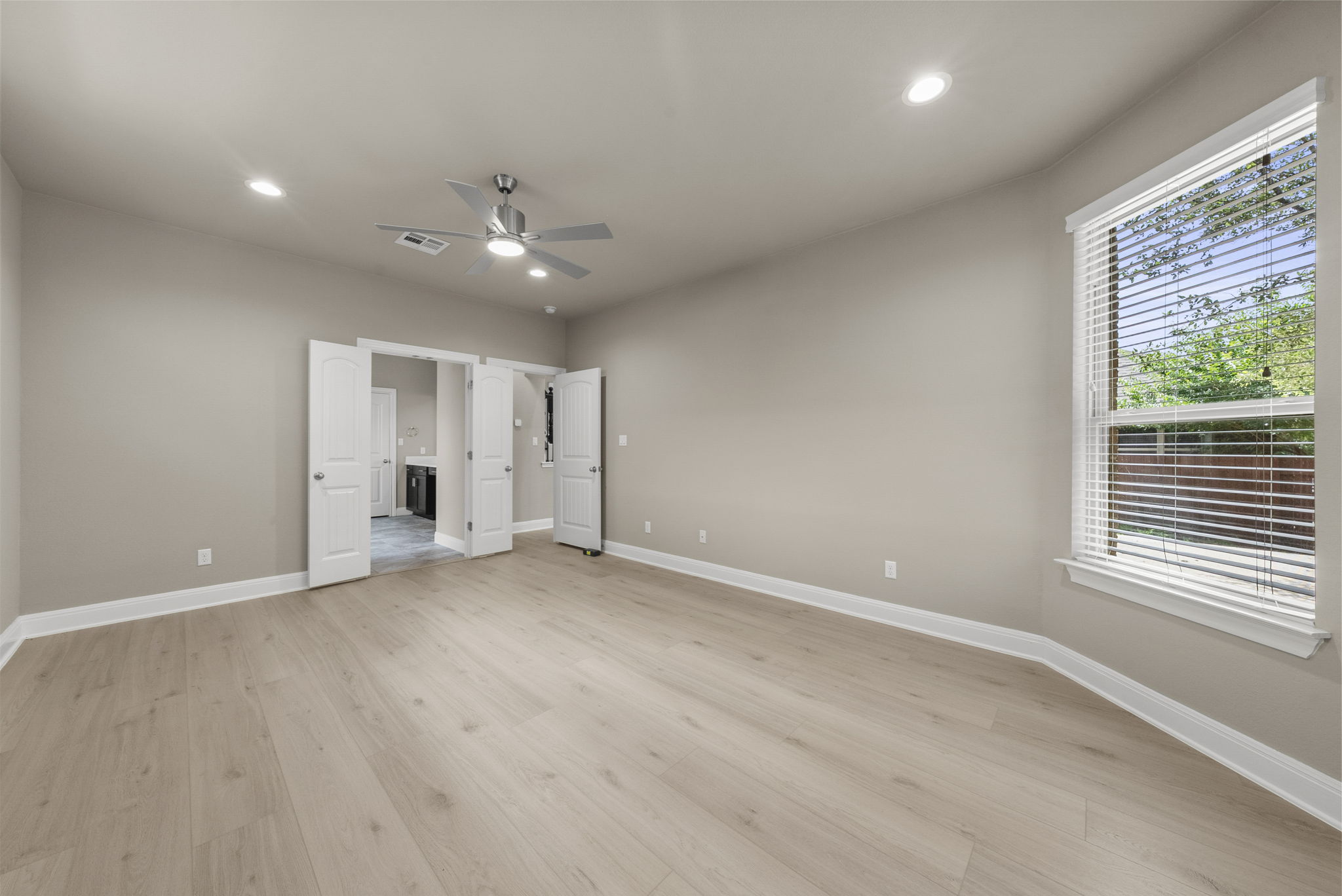 4401 Trinity Woods Street Leander, TX 78641 - Photo 21 of 37 A generous, light-filled bedroom features modern flooring and a refreshing ceiling fan.
