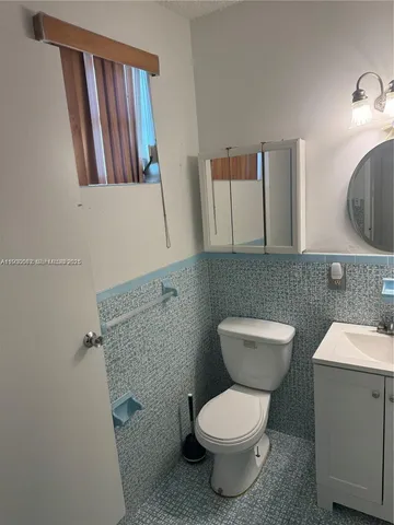 a bathroom with a toilet a sink and mirror