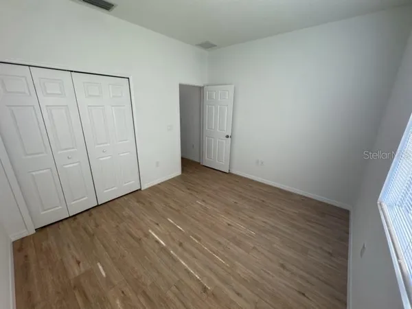 a view of an empty room with wooden floor