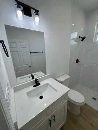 a bathroom with a sink a toilet and shower