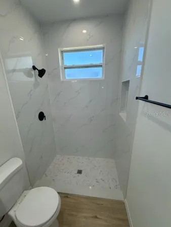 a bathroom with a shower a toilet and a sink