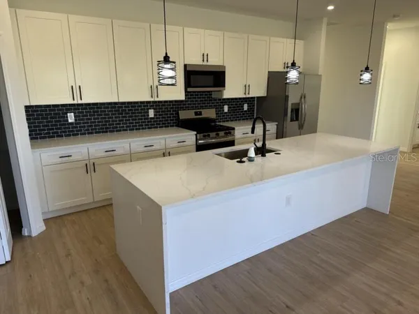 a kitchen with a sink a stove a microwave and cabinets