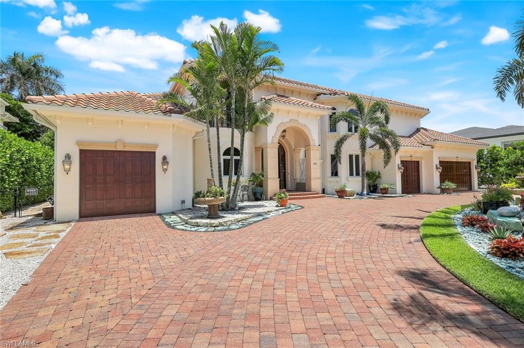 a view of a white house with a yard and potted plants