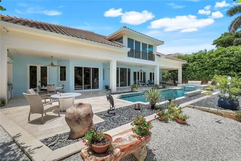 a view of a house with backyard sitting area and swimming pool