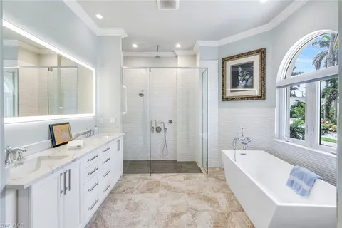 a bathroom with a tub a sink and a large mirror