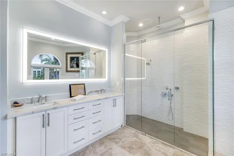 a bathroom with a granite countertop sink a mirror a vanity and a shower