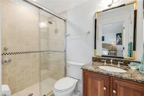 a bathroom with a granite countertop sink a mirror and a shower