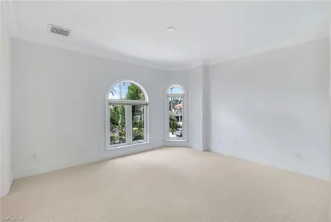 a view of a big room with windows and chandelier fan