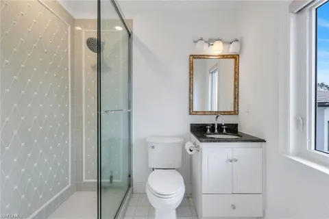 a bathroom with a granite countertop toilet a sink and mirror