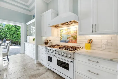 a kitchen with granite countertop a stove a sink and a wooden floors