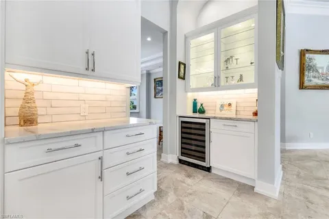 a kitchen with granite countertop white cabinets and appliances