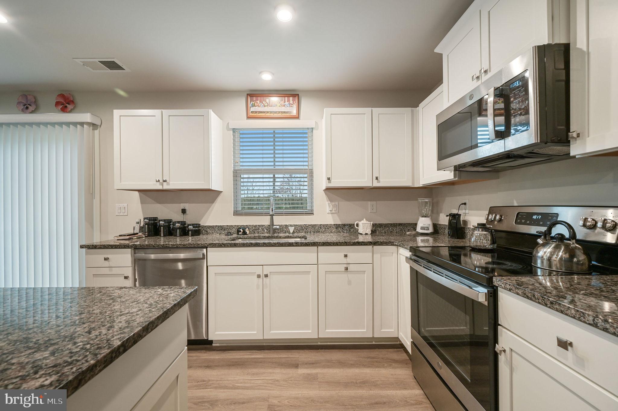 421 Laertes Drive Dover, DE 19901 - Photo 15 of 29 a kitchen with stainless steel appliances granite countertop a stove a sink and a microwave