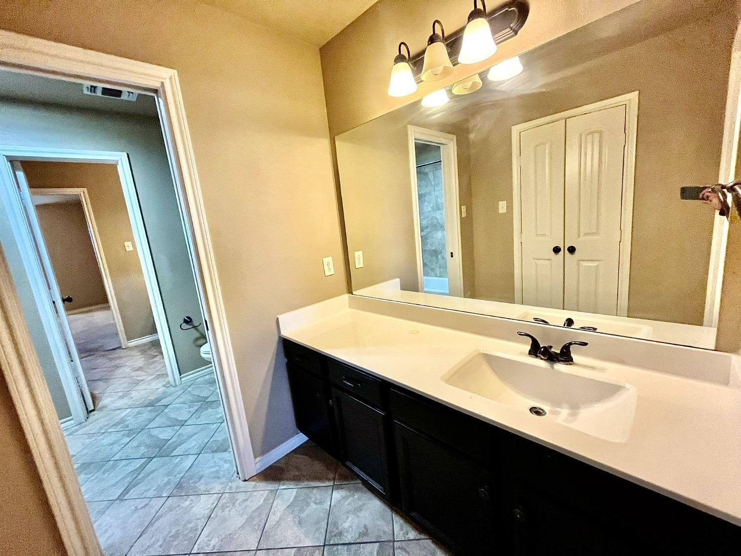 4419 106th Street, Unit B Lubbock, TX 79424 - Photo 14 of 20 a bathroom with a sink and a mirror