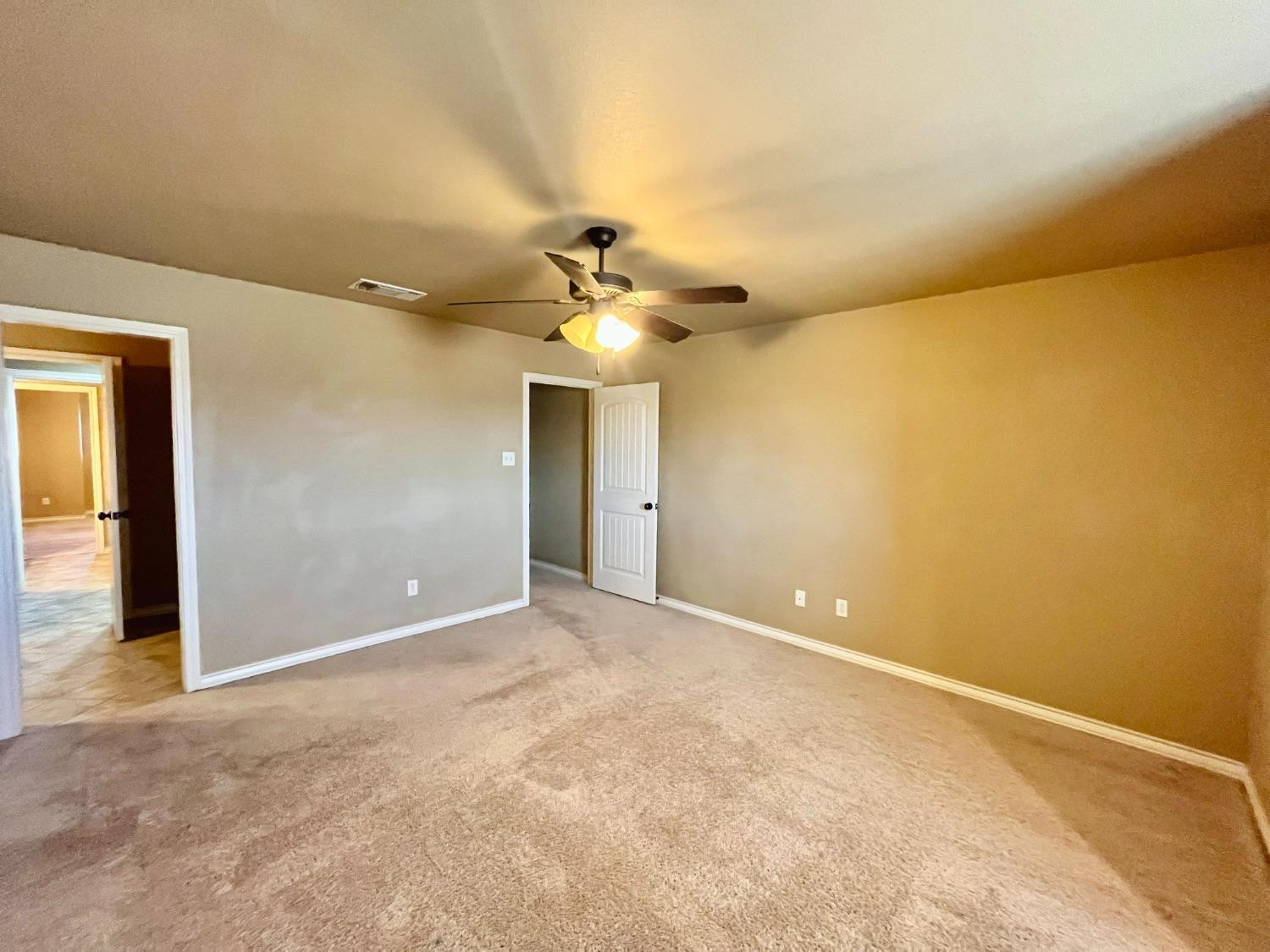 4419 106th Street, Unit B Lubbock, TX 79424 - Photo 17 of 20 an empty room with a empty space and a ceiling fan
