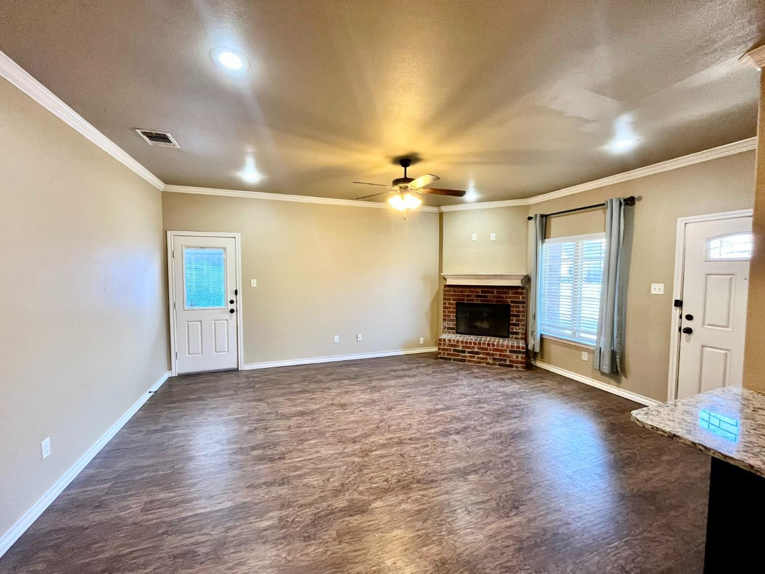 4419 106th Street, Unit B Lubbock, TX 79424 - Photo 2 of 20 an empty room with wooden floor and fireplace