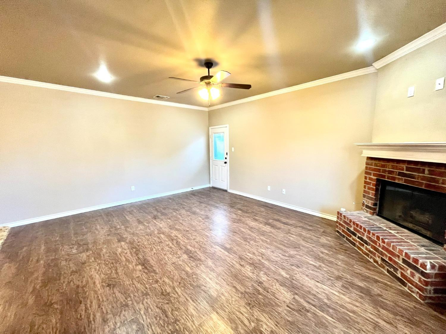 4419 106th Street, Unit B Lubbock, TX 79424 - Photo 3 of 20 a view of empty room with wooden floor and fireplace