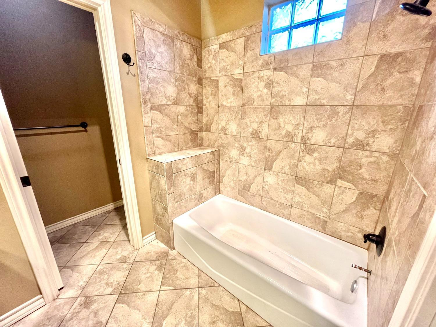 4419 106th Street, Unit B Lubbock, TX 79424 - Photo 8 of 20 a bathroom with a tub and shower