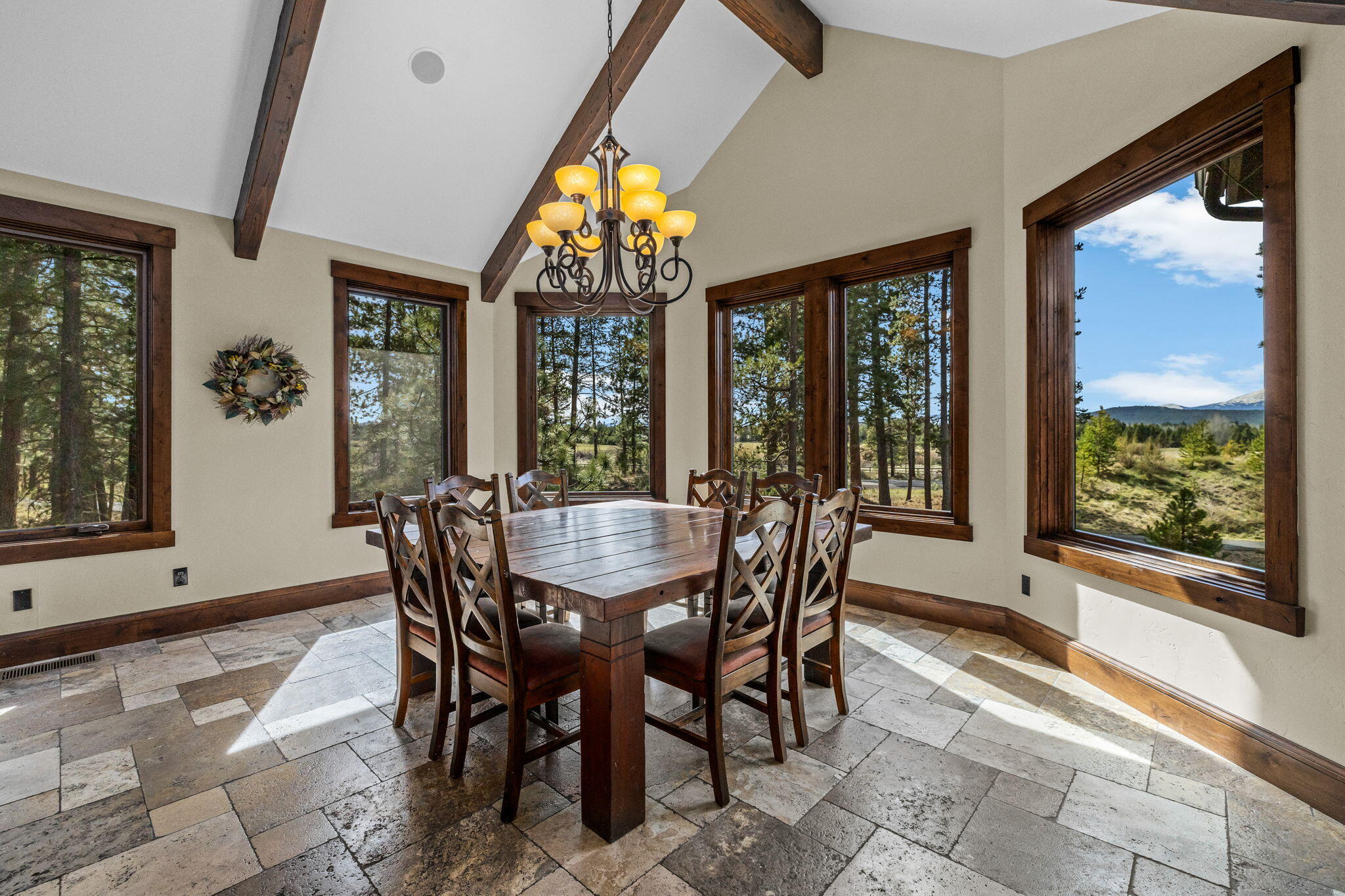 56373 Trailmere Circle Bend, OR 97707 - Photo 17 of 102 a view of a dining room with furniture large windows and wooden floor