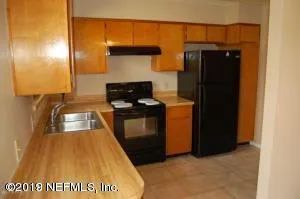 a kitchen with a refrigerator and a stove