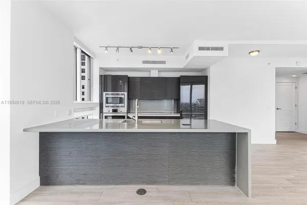 a view of a kitchen with a sink and wooden floor