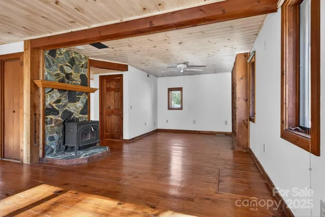 a view of a hallway with wooden floor and windows