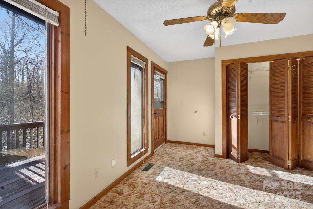 241 Pinefield Drive Tryon, NC 28782 - Photo 30 of 39 a view of a bedroom with a bed and a chandelier fan