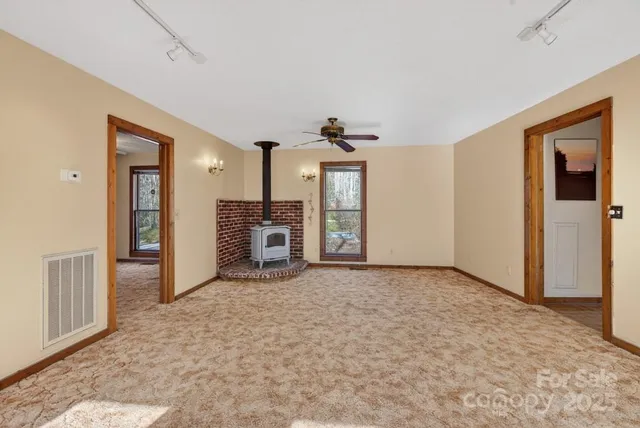 an empty room with kitchen view and a window