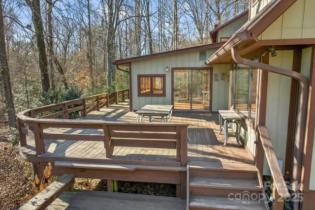 a view of a patio with table and chairs with wooden floor and fence
