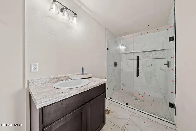 a bathroom with a granite countertop sink a shower and mirror
