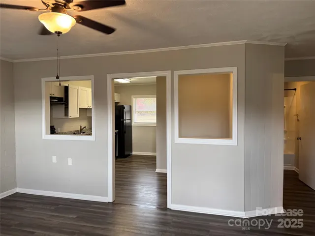 a view of a hallway with wooden floor and chandelier