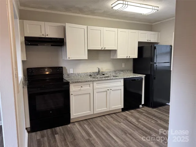 a kitchen with a refrigerator and a stove top oven