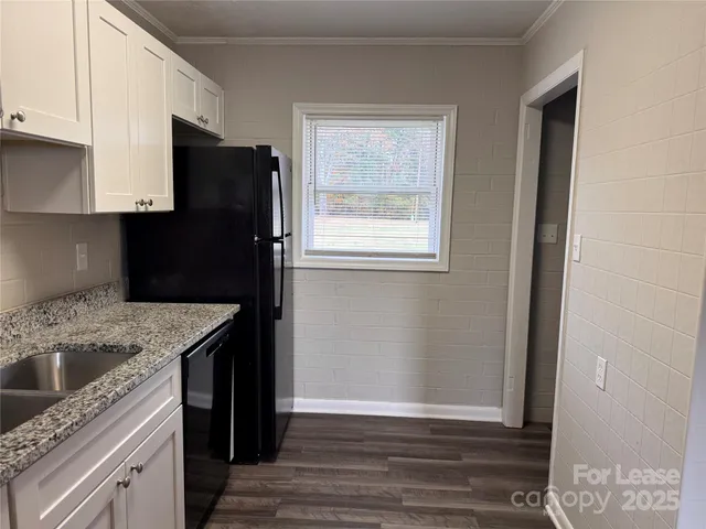 a kitchen with granite countertop a refrigerator and a sink