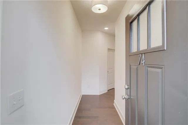a view of an empty room with wooden floor and a fireplace