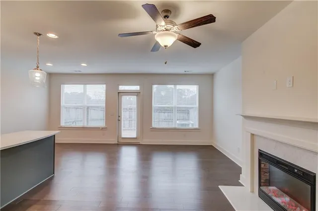 an empty room with windows and fireplace