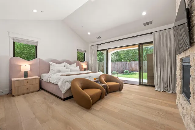 a bedroom with a bed a mirror and a large window