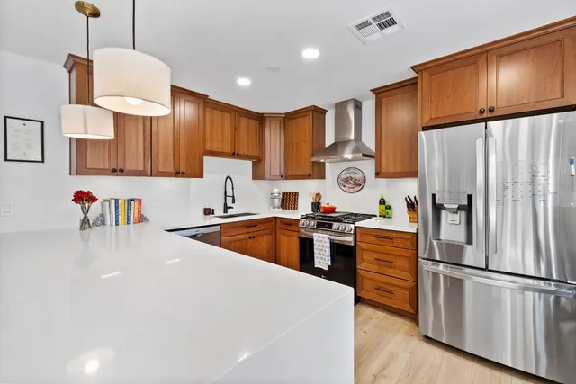 a kitchen with stainless steel appliances granite countertop a refrigerator sink and cabinets