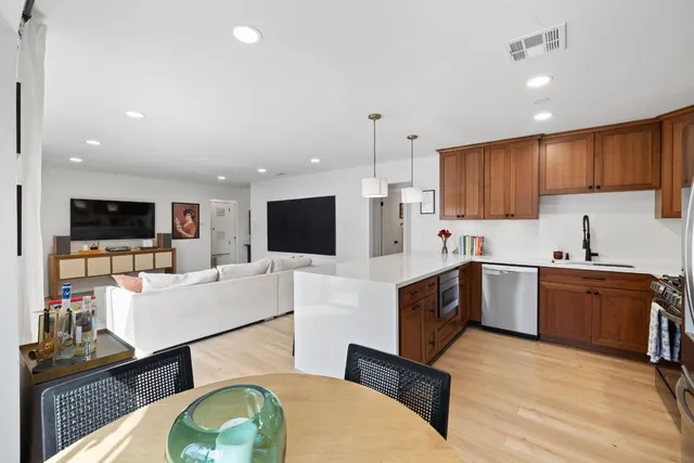 a large white kitchen with a large window and stainless steel appliances