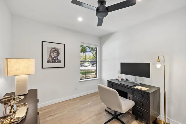 a view of a workspace with furniture and a window